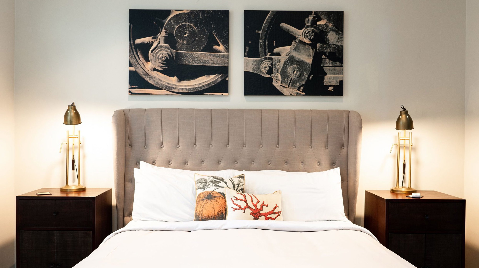 A vibrant dog park bathed in sunlight features abundant greenery with mature trees, offering ample shade for leisurely outdoor activities. In the distance is a well-equipped playground that presents an additional activity area. An inviting picnic table spreads out nearby, ideal for enjoying meals al fresco or taking relaxing breaks from play. A neatly-placed trash bin aids in maintaining the park's cleanliness for everyone's enjoyment. Dominating the scene is a generously wide dirt path gracefully curving through the expanse of grass, promising exploratory walks and lively fetch games.